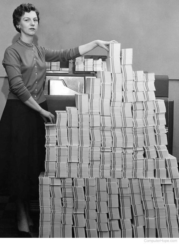 Woman standing next to thousands of punch cards