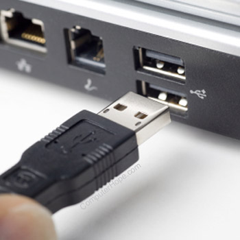 USB cable being plugged into USB port on laptop