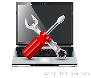 Screwdriver and wrench over a laptop.